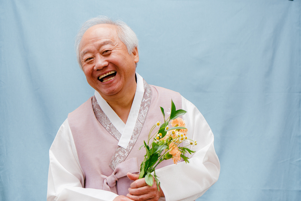 Studio Portrait of a Man Wearing a Hanbok Holding Flowers